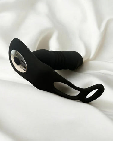 a prostate massager laying on top of a white sheet